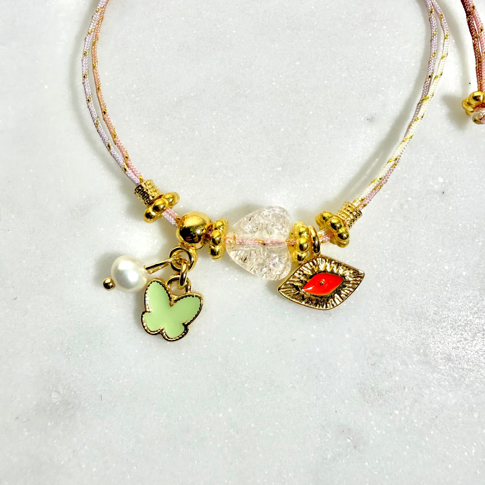 μαρτάκι χειροποίητο σε πολυχρωμο παλ κορδόνι με επίχρυσες λεπτομέρειες και διακριτικά charms πεταλούδα και ματάκι