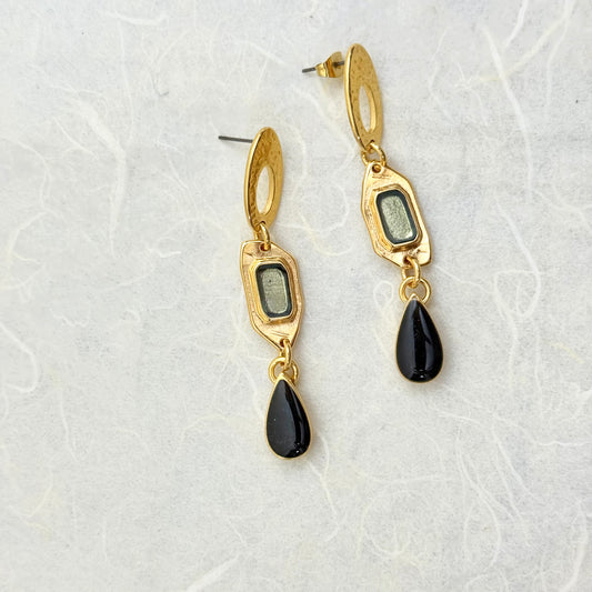 κρεμαστά, καρφωτά, επιχρυσωμένα ορειχάλκινα σκουλαρίκια με στοιχείο ενωτικό πολύγωνο και μαύρο στοχείο σε σχήμα δάκρυ