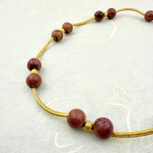 κολιέ με χρυσά μεταλλικά στοιχεία τύπου σωλήνα και στρογγυλές χάντρες σε βουργουνδί αποχρώσεις